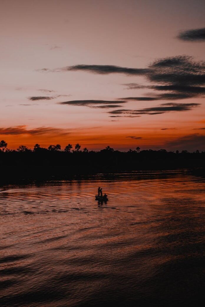 sunset over rio negro with silhouetted fishing boat