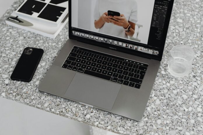 gray laptop on white and black marble table