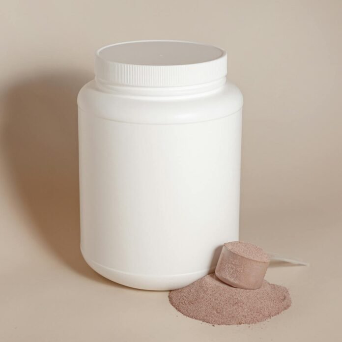 white plastic container without a label and a pile of dry food with a clear spoon