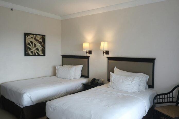 Quartos de hotel com duas camas confortáveis e iluminação acolhedora em Goiânia.