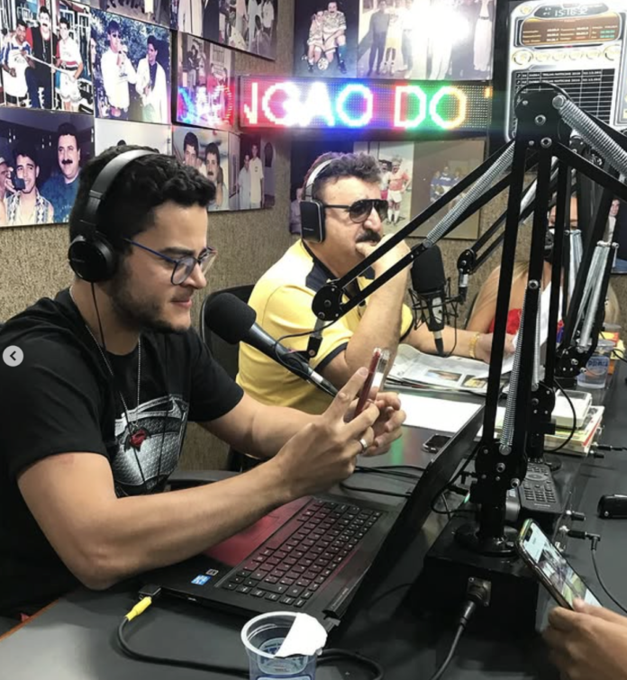 Influenciadores de Brasília: Vamos relembrar Eldo Gomes no rádio da capital Brasília sempre revelou talentos que transitam entre diferentes plataformas, e o rádio — um dos meios mais tradicionais da comunicação — também faz parte dessa trajetória. Entre os nomes que já marcaram presença nas ondas sonoras da capital, o jornalista e influenciador Eldo Gomes soma experiências que ajudam a contar a evolução da comunicação local. Em um momento especial da sua carreira, Eldo participou de um dos programas mais populares da rádio brasiliense: o “Domingão do Vingão”, atração que conquistava o público com uma mistura de música, entretenimento e entrevistas descontraídas. Na época, o programa era considerado um dos maiores sucessos da programação da Rádio Atividade FM, reunindo audiência fiel e grande repercussão entre os jovens.