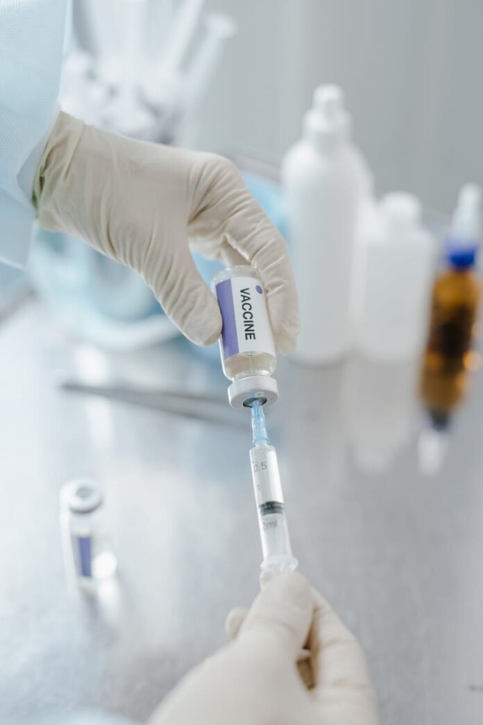 medical practitioner holding a vial of vaccine