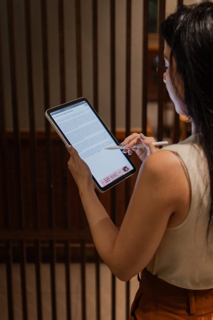 businesswoman reviewing document on tablet indoors