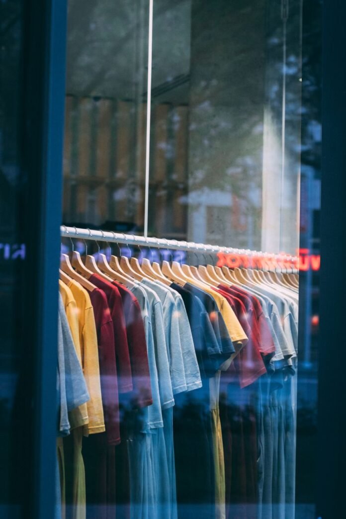 colorful clothes on hangers behind window