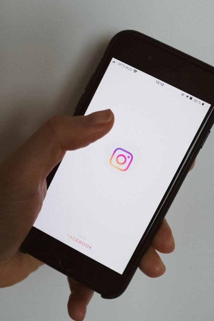 crop unrecognizable person with smartphone using social media application