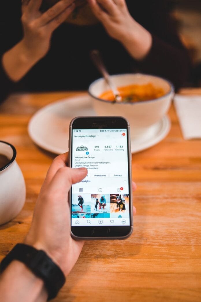 faceless man surfing internet on smartphone while girlfriend dining